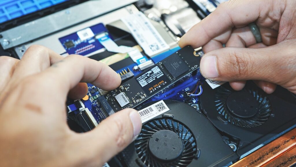 A man inserting a M2 SSD card on his laptop. Concept image of if 500GB SSD is good for gaming?