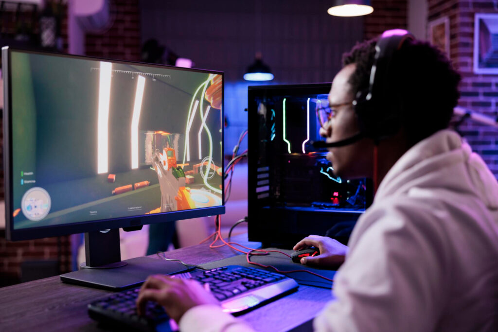 A man playing on a gaming monitor in a RGB lighting setup/