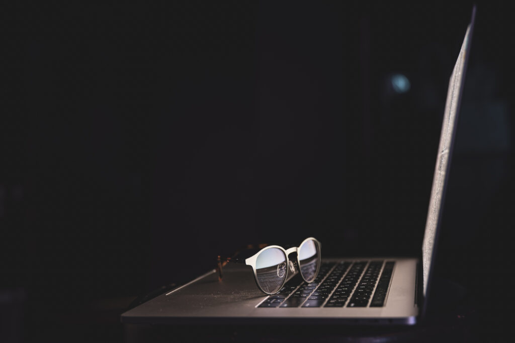 A Gigabyte laptop placed on a table along with glasses on it.