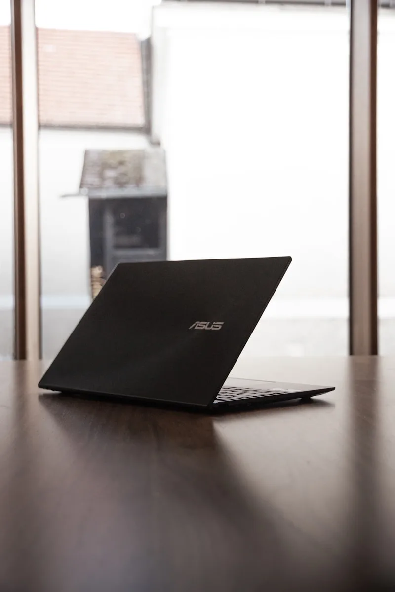 Asus ROG a laptop computer sitting on top of a wooden table